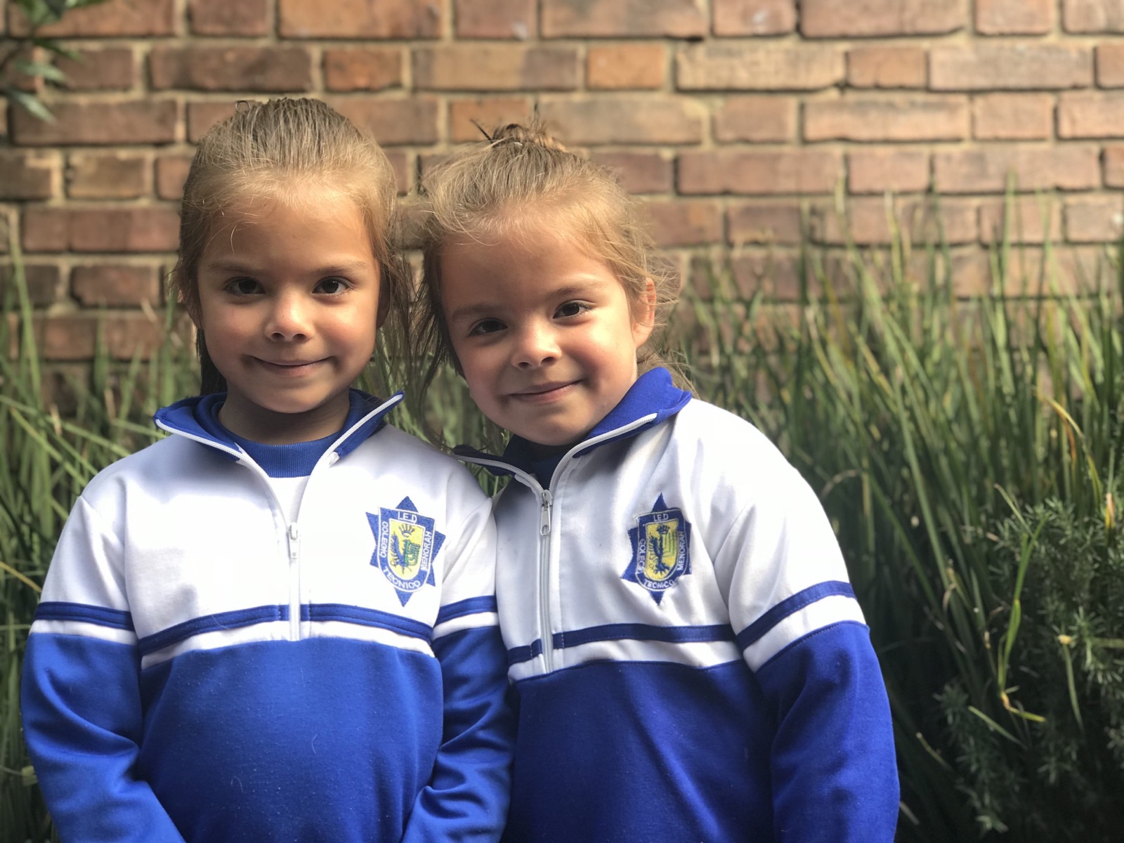 Dos niñas pequeñas con la sudadera del colegio